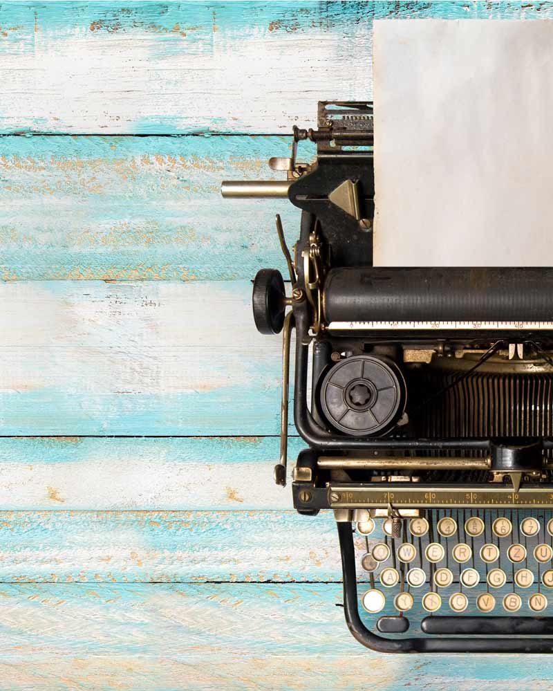 A typewriter on a distressed blue wood surface