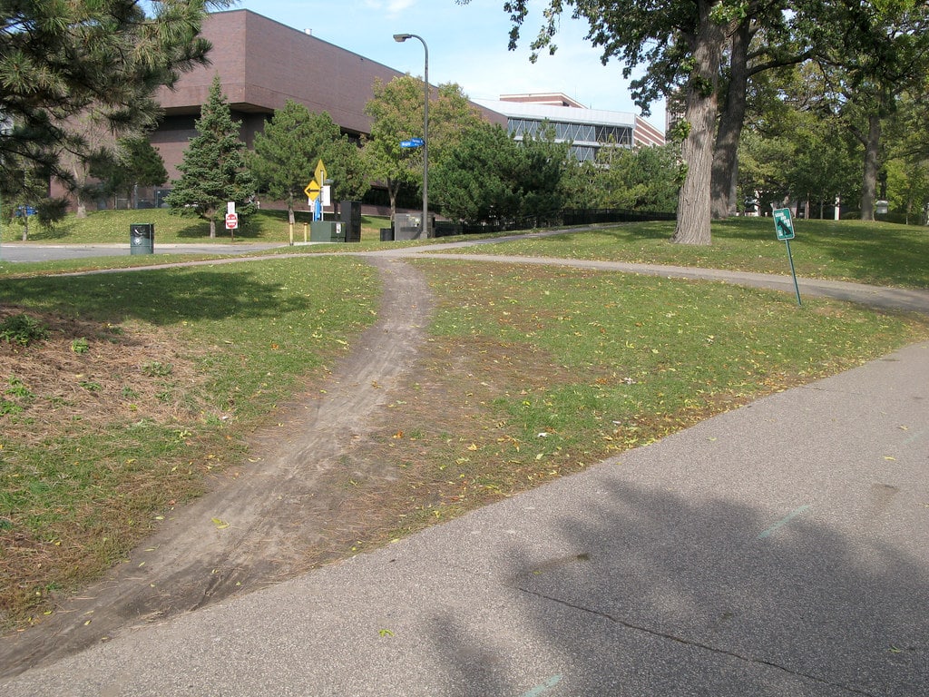 An example of a desire path cutting across a walkway corner