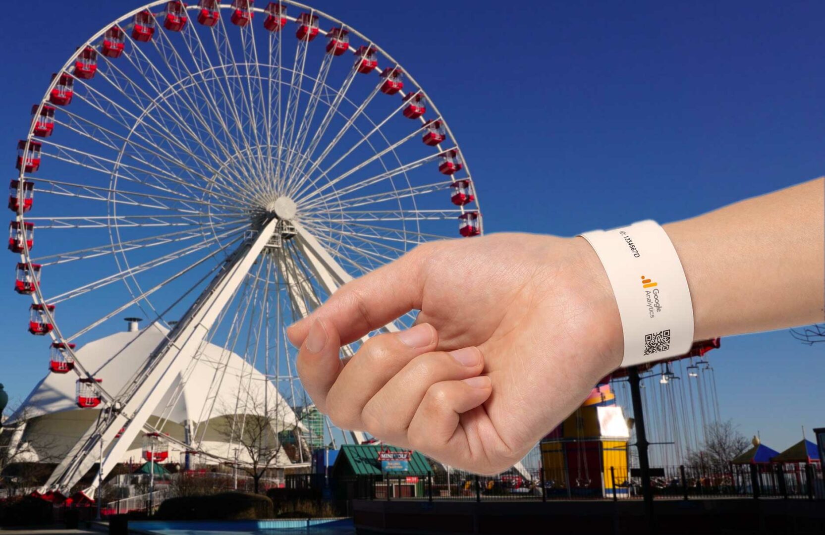 A Google Analytics wristband on a wrist with a theme park in the background