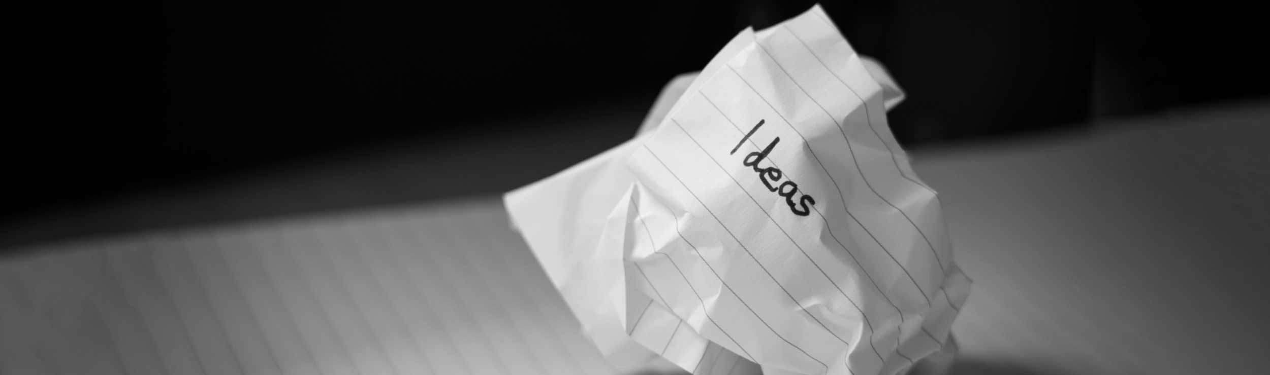 A screwed up ball of paper with the word "ideas" written on it