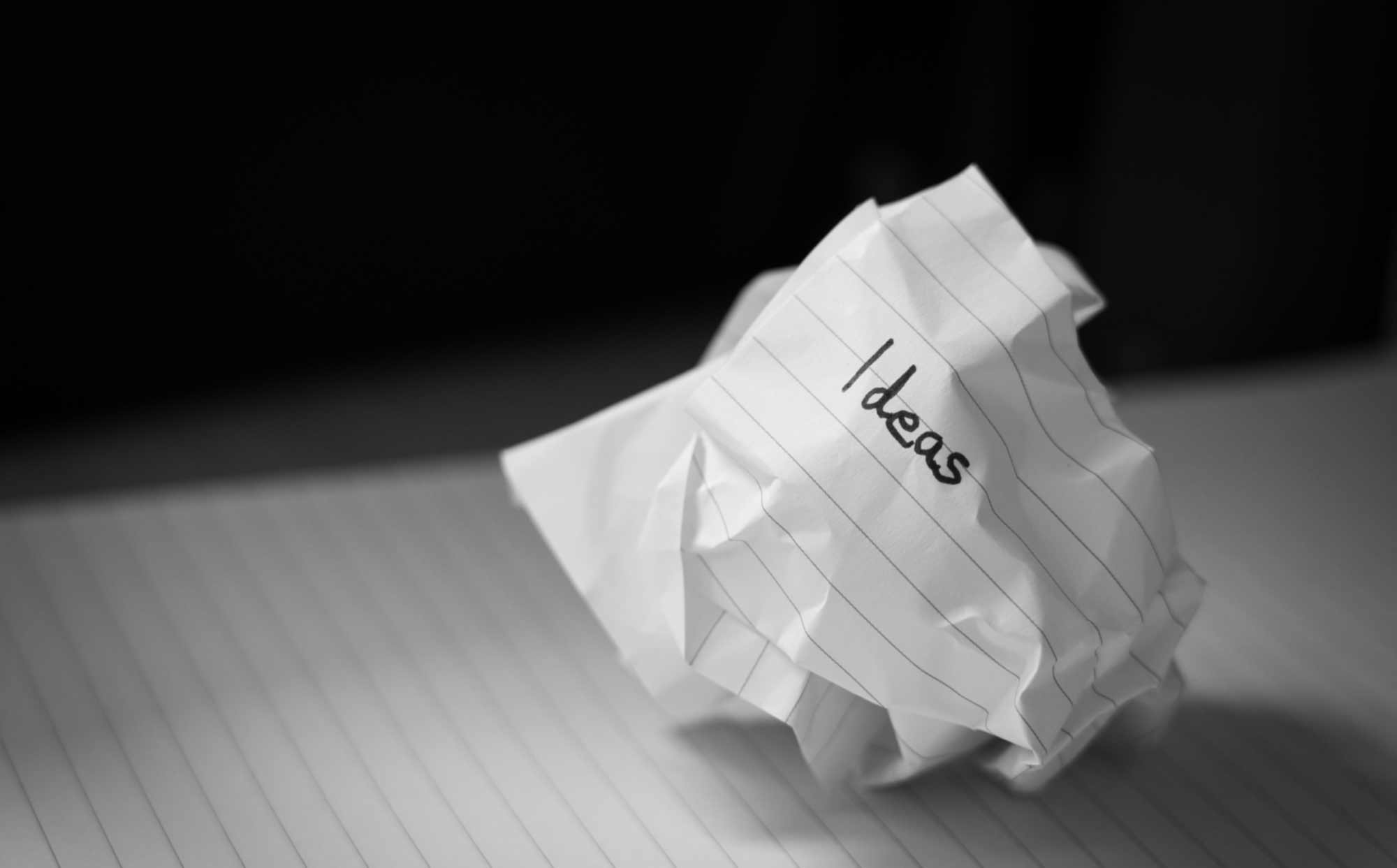 A screwed up ball of paper with the word "ideas" written on it
