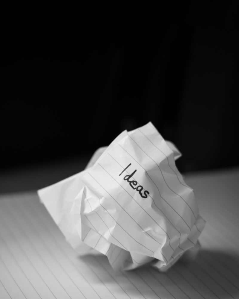 A screwed up ball of paper with the word "ideas" written on it